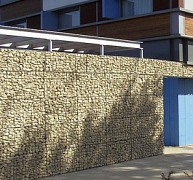 Látványos homlokzatburkolat kövekkel töltött drótkosarakból Látványos homlokzatburkolat kövekkel töltött drótkosarakból